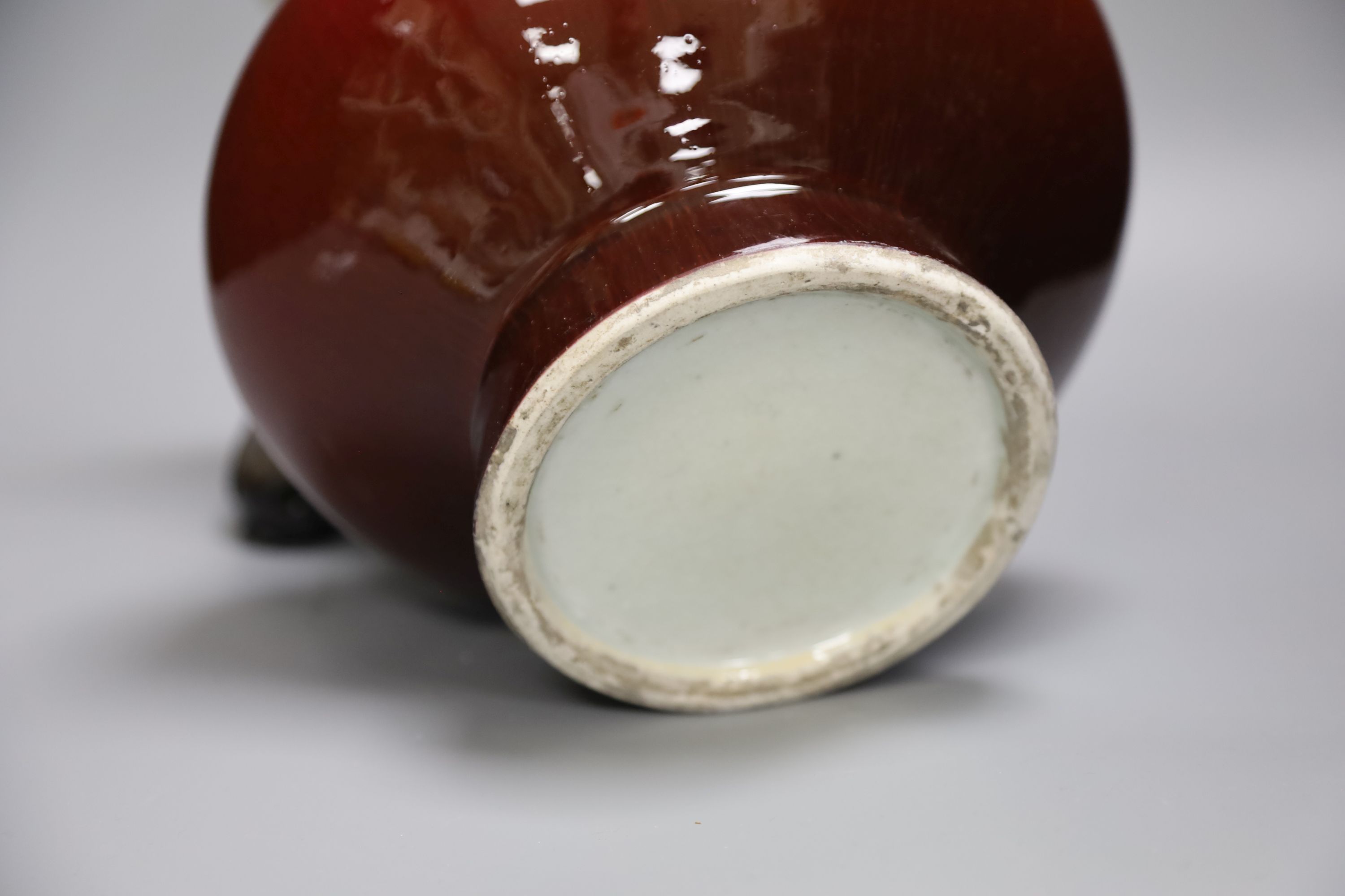 A 19th century Chinese sang de boeuf vase of squat baluster form with everted rim (a.f.), on square hardwood stand, overall height 35.5